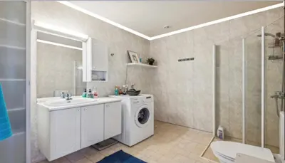 a bathroom with a washing machine and a sink at Sentral og romslig leilighet på Levanger in Levanger