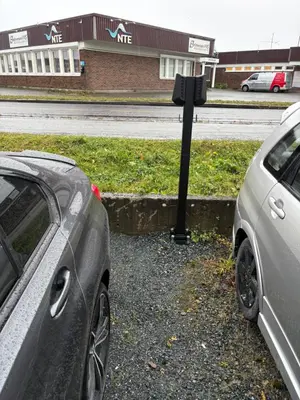 two cars parked next to a parking meter at Sentral og romslig leilighet på Levanger in Levanger