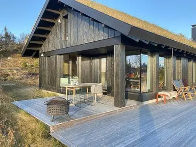 a house with a deck with a table and chairs at Mountain Cabinin Valdres in Aurdal