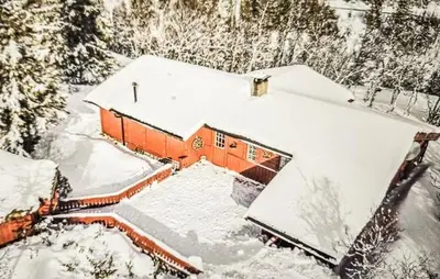 an orange house covered in snow with trees at Cabin With Terrace And Mountain Views In Tuddal in Tuddal