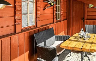 a wooden table and chairs and a wooden table and a table and a wooden table at Cabin With Terrace And Mountain Views In Tuddal in Tuddal