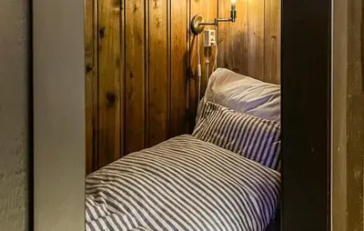 a bedroom with a bed with a wooden wall at Cabin With Terrace And Mountain Views In Tuddal in Tuddal