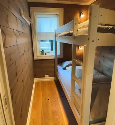 a bunk bed in a tiny house with a window at Sentral leilighetshytte 16A in Stranda