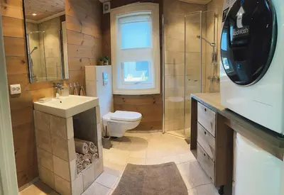 a bathroom with a toilet and a sink and a shower at Sentral leilighetshytte 16A in Stranda