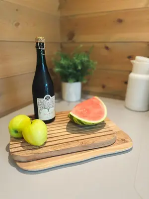 a bottle of wine and fruit on a cutting board at Sentral leilighetshytte 16A in Stranda