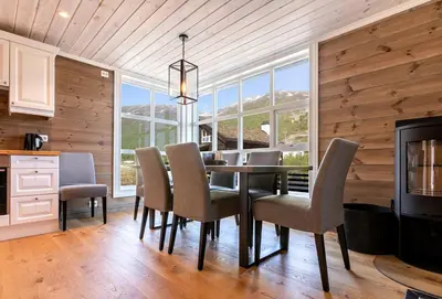 a dining room with a table and chairs and a fireplace at Stranda Fjellgrend 3 bedrooms - 12A in Stranda