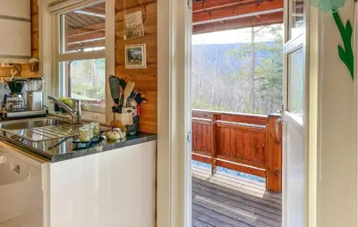 a kitchen with a counter and a large window at Pet Friendly Home In Lesjaskog With Wifi in Bjorli