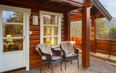 two chairs and a table on the porch of a cabin at Pet Friendly Home In Lesjaskog With Wifi in Bjorli