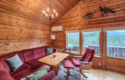 a living room with a red couch and a wooden wall at Amazing Home In Skare With Sauna in Skare