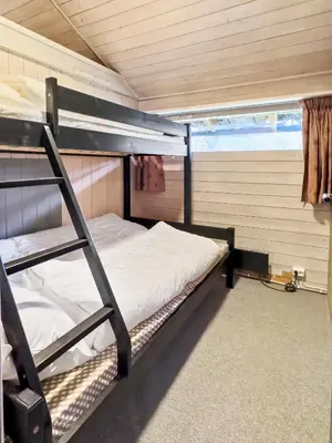 a bedroom with a bunk bed and a ladder at Utsikt mot fjellene Ski in out 16 sengeplasser in Aurdal