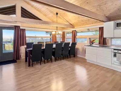 a kitchen and dining room with a table and chairs at Utsikt mot fjellene Ski in out 16 sengeplasser in Aurdal