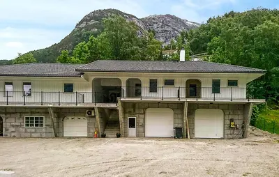 a house with three garage doors and a mountain at Awesome Apartment In Eidfjord in Eidfjord