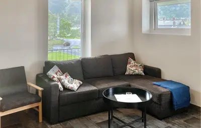 a living room with a couch and a table and a chair at Awesome Apartment In Eidfjord in Eidfjord