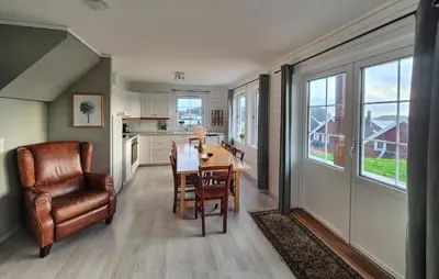 a kitchen and dining room with a table and a chair at Beautiful Home In Bøvågen With Sauna in Bøvågen