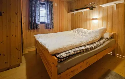 a small bed in a wooden room with a window at Awesome Home In Hemsedal With Sauna in Hemsedal