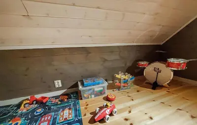 a room with a bed and toys on a wooden floor at 3 Bedroom Awesome Home In Strandebarm in Strandebarm