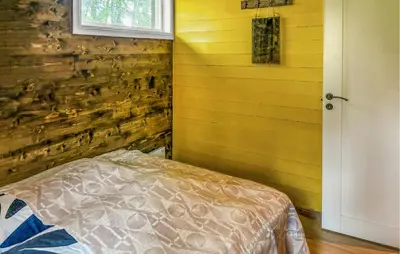 a bedroom with a wooden wall with a bed in it at Stunning Home In Røros With Sauna in Røros
