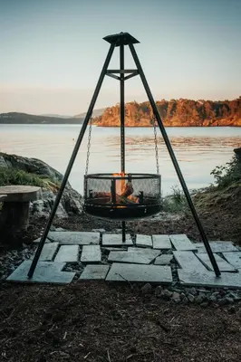 a swing with a fire in it next to a body of water at Furiholmen in Askøy