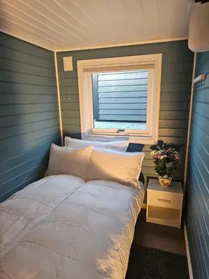 a small bedroom with a bed and a window at Furiholmen in Askøy