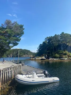 a white boat parked next to a dock at Furiholmen in Askøy