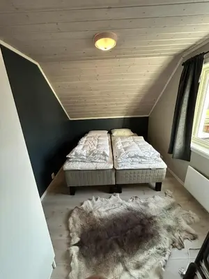 two twin beds in a room with a rug at Villa Isfjorden in Isfjorden