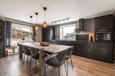 a kitchen with a wooden table and chairs at Spacious Hemsedal home with ski slope view in Hemsedal