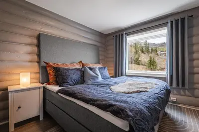 a bedroom with a large bed with a window at Spacious Hemsedal home with ski slope view in Hemsedal
