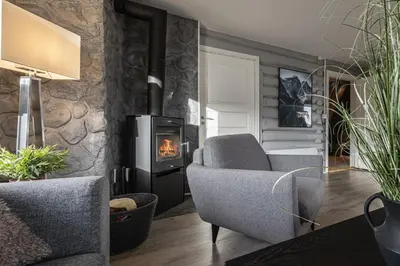 a living room with a chair and a fireplace at Spacious Hemsedal home with ski slope view in Hemsedal