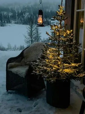a christmas tree with lights next to a couch at Family-Friendly Seter Cabin Near Makalaus Peak in Reinli