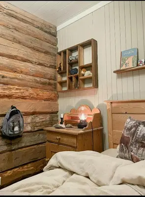 a bedroom with a bed and a wooden wall at Family-Friendly Seter Cabin Near Makalaus Peak in Reinli