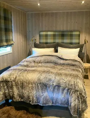a bedroom with a large bed with a blanket at Sunny Cabin With Panoramic Views At Golsfjellet in Tisleidalen