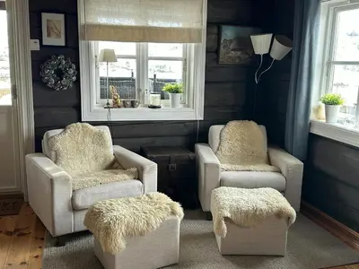 a living room with two chairs and a table at Log Cabin By Hardangervidda National Park in Nesland