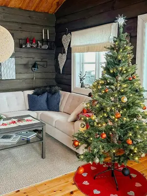 a christmas tree in a living room with a couch at Log Cabin By Hardangervidda National Park in Nesland