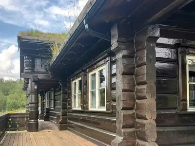 a log cabin with windows and a wooden deck at Log Cabin By Hardangervidda National Park in Nesland