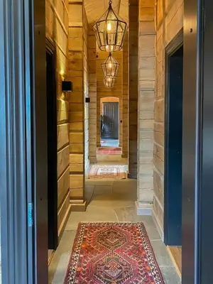 a hallway with a rug and a chandelier at Large Dream Cabin On Vegglifjell in Veggli
