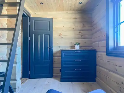 a room with a blue dresser and a staircase at Large Dream Cabin On Vegglifjell in Veggli