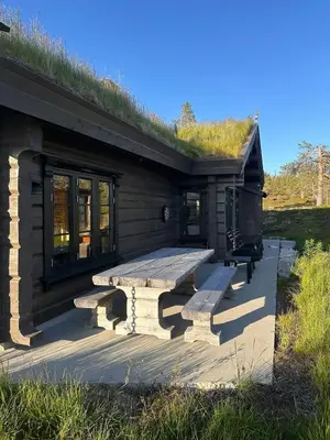 a cabin with a bench and a grass roof at Large Dream Cabin On Vegglifjell in Veggli