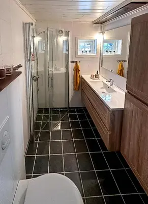 a bathroom with a shower and a sink and a toilet at Modern Hand-Crafted Log Cabin in Dovreskogen