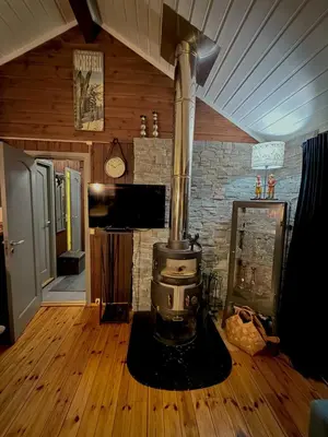 a kitchen with a stove in the middle of a room at Utibakken - cabin ski inn-out Norefjell in Surteberg