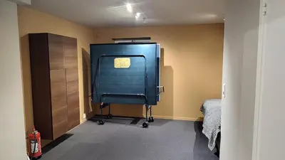 a room with a blue cabinet and a bed at Splitter ny leilighet i sokkel på enebolig in Vikhammer