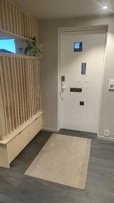 a hallway with a white door and a rug at Splitter ny leilighet i sokkel på enebolig in Vikhammer