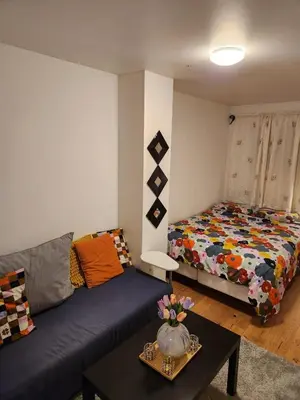 a living room with a couch and a bed at Nice Apartment in Sjetnemarka - Free parking and WiFi in Trondheim