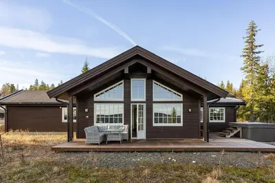 a house with a large window and a deck at Jantelaaven in Trysil