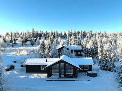 a house covered in snow with trees in the background at Jantelaaven in Trysil