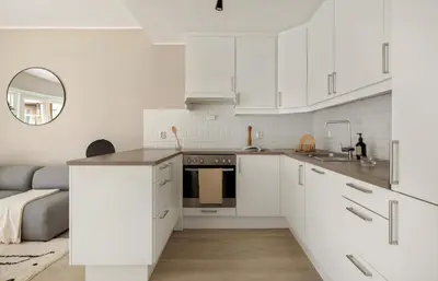 a white kitchen with white cabinets and a sink at Great apartment in Bergen! in Lii