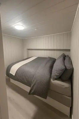 a bedroom with a bed in a small room at Sentralt og elegant opphold nær alt in Lillehammer