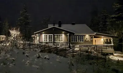a house with a porch in the snow at night at Cabin With Ski-Inout And Hot Tub In Fageråsen in Trysil
