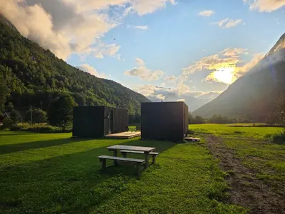 a picnic table sitting in a field with two buildings at Nygård Panorama in Stryn