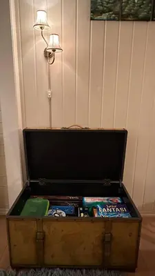 an old trunk filled with games and a lamp at Casa Hauge - Fjord View in Sandane