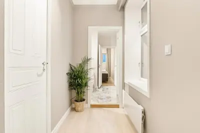 a hallway with a white door and a potted plant at Modern Apartment in Bergen